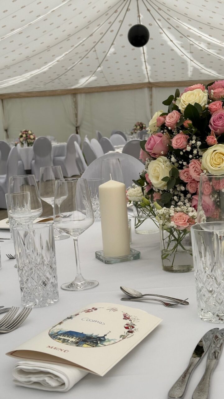 Eine schön eingedeckte Tafel von CSL Catering in München mit Kerzen und Blumendeko auf einer Hochzeit in München