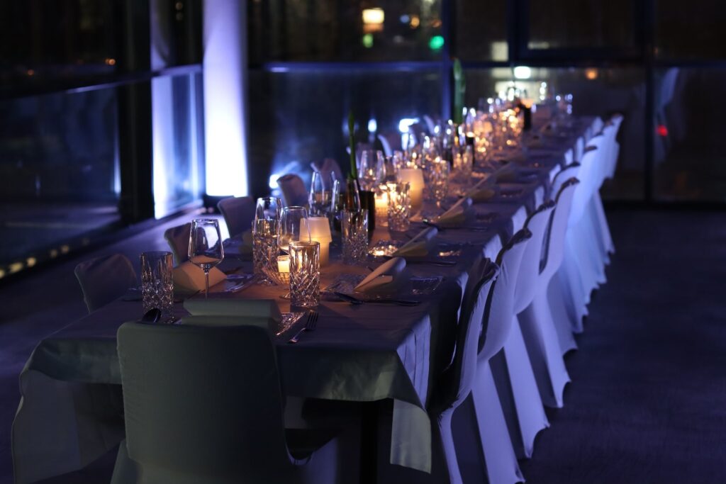 Exklusive, gemütliche Eventlocation mit schick eingedeckter Tafel im Kerzenschein von CSL Catering